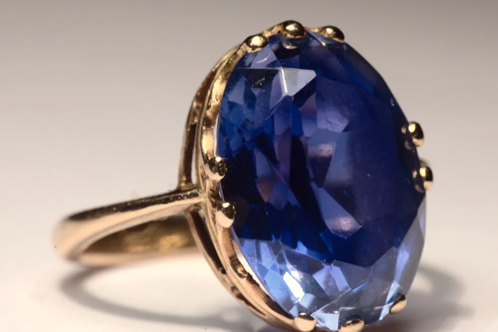 A large faceted oval blue sapphire set in a gold ring