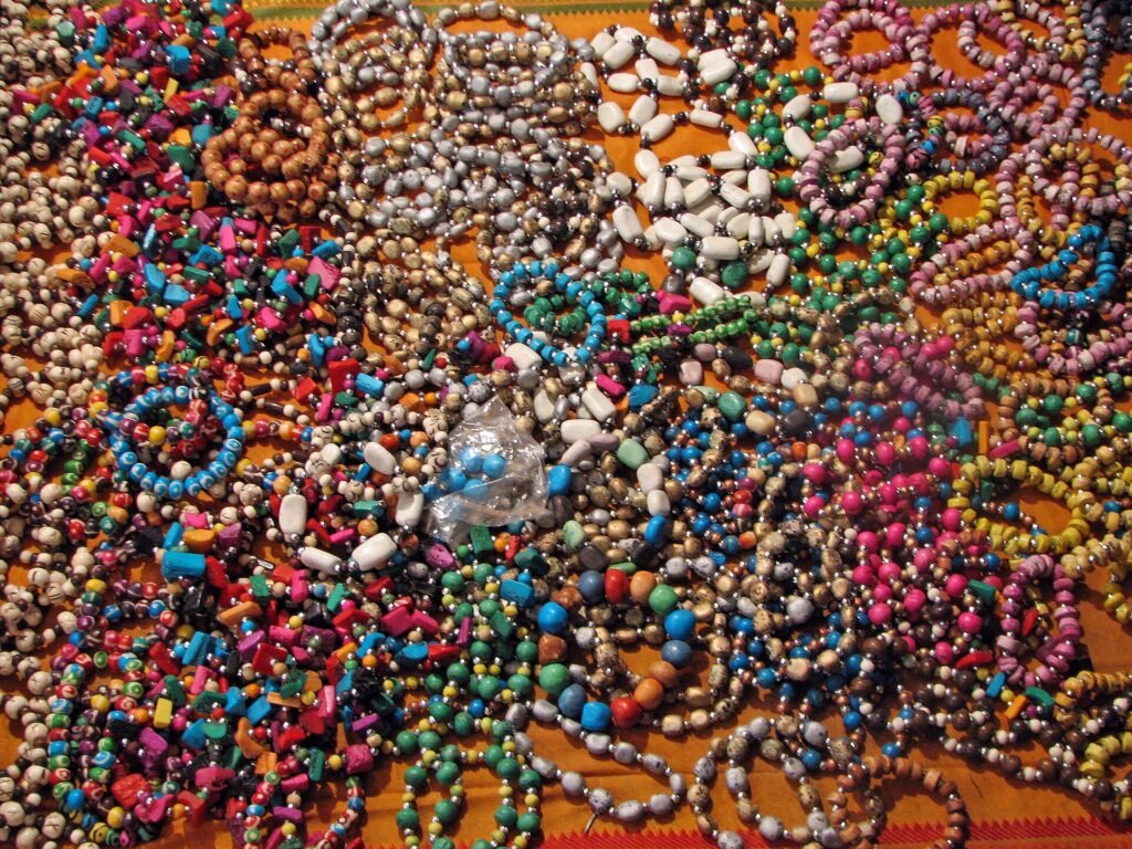 Hundreds of colourful bead bracelets laid out on a cloth for sale in Rishikesh