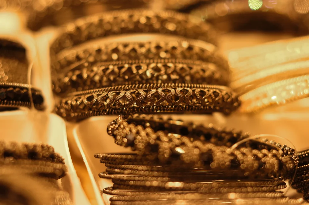 Stacks of patterned yellow gold bangles in a jewellery shop display