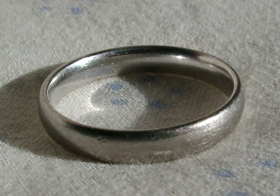 A plain white gold band with a bright rhodium-plated finish